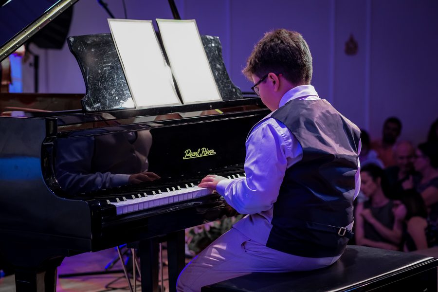 Young student performing piano at a music recital